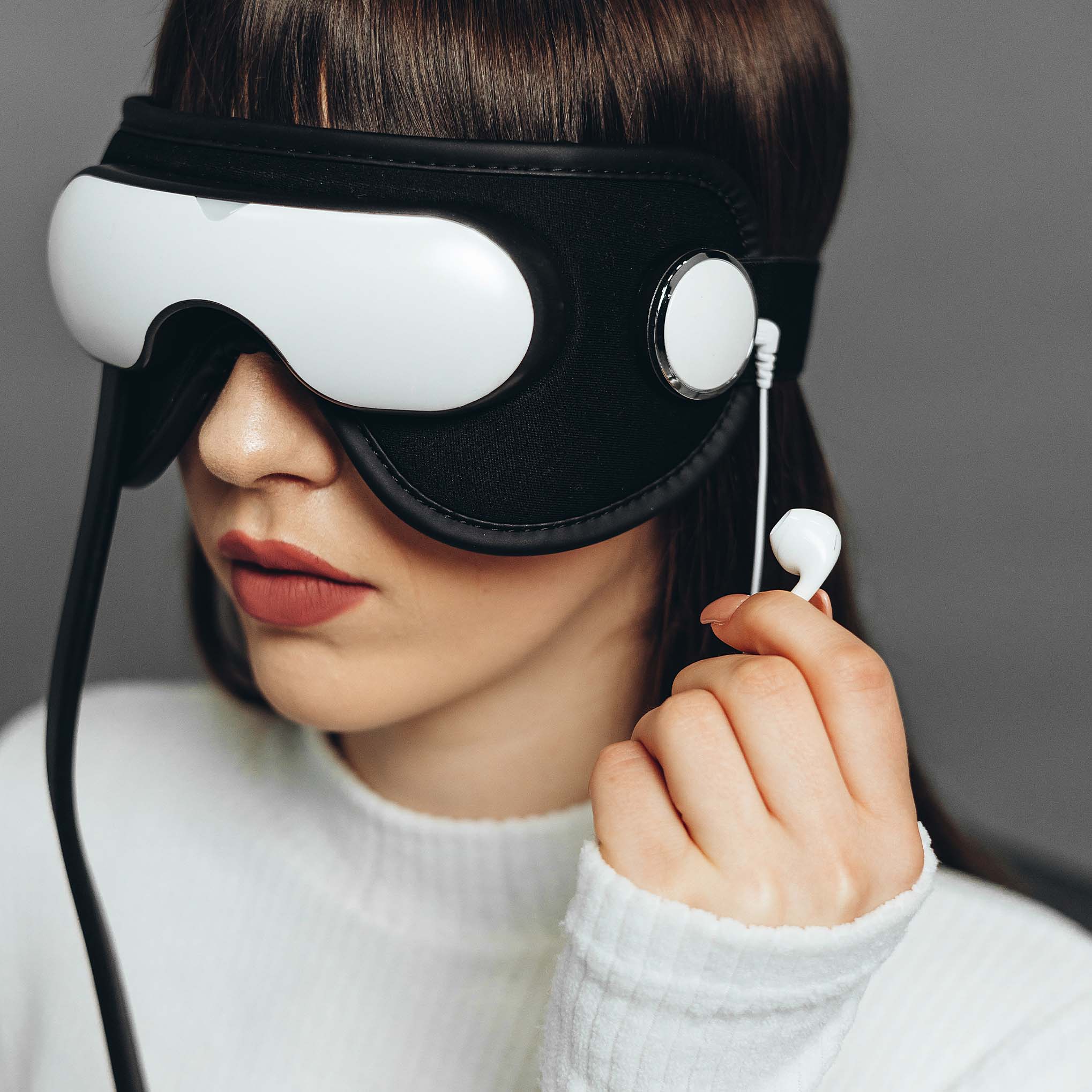 Жінка в кріслі використовує масажер EyeCare Pro для очей