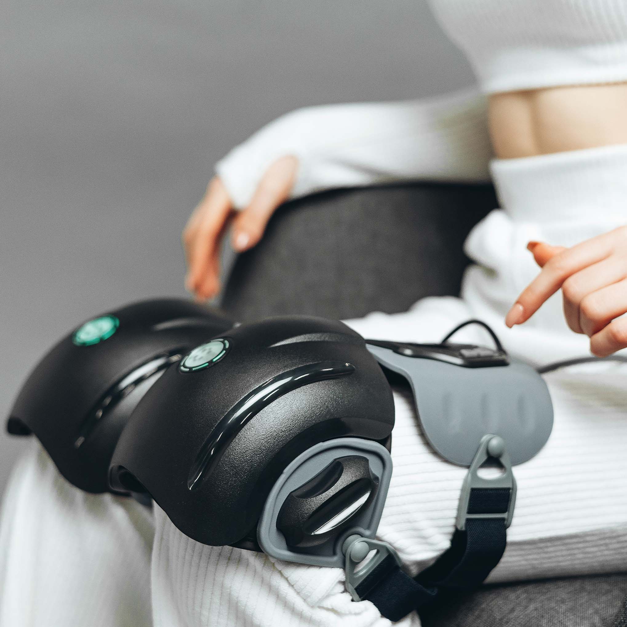 Жінка тримає коробку масажера KneeThermo+ Vibe для колін