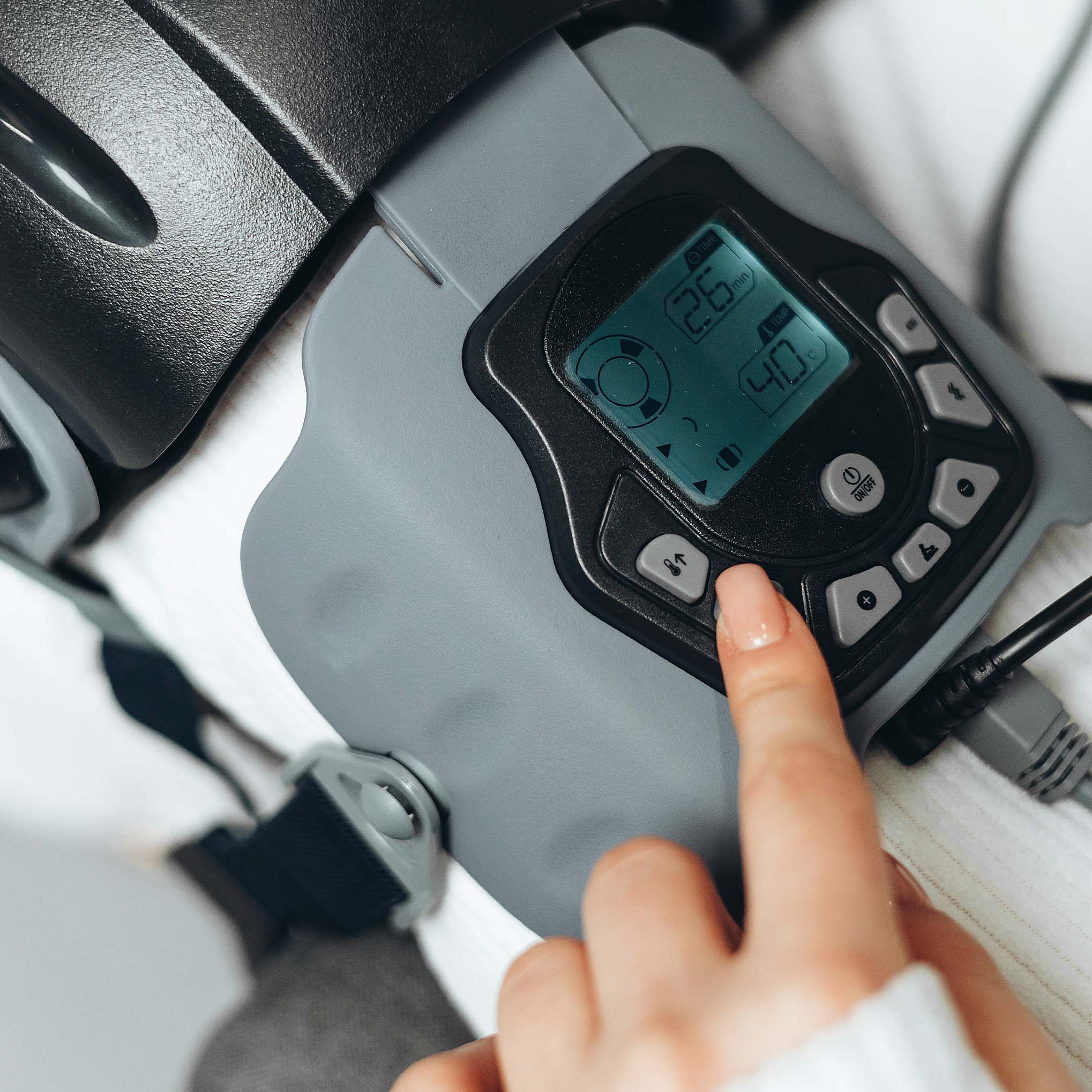 Жінка тримає KneeThermo+ Vibe у руці, готова до використання