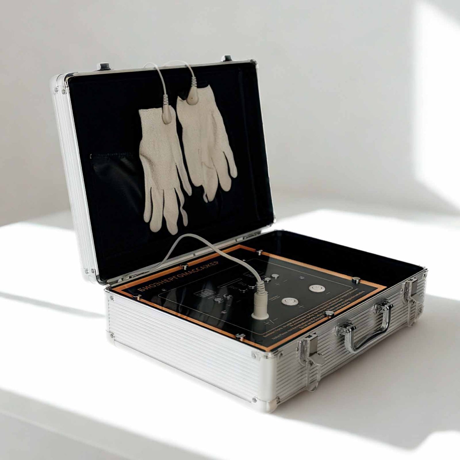 Апарат NeuroPulse EMS Pro — вигляд спереду з рукавичками зі срібною ниткою